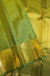 Green saree with gold zari border, showcasing elegant gold detailing on rich green fabric.