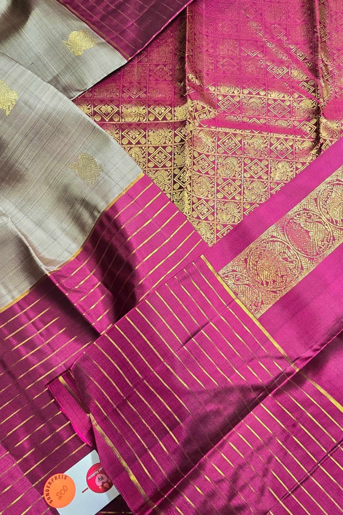 Pink and gold patterned fabric with a brand label in the corner