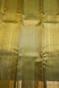 Green saree with gold zari border showcasing intricate patterns and rich tones for ethnic wear.