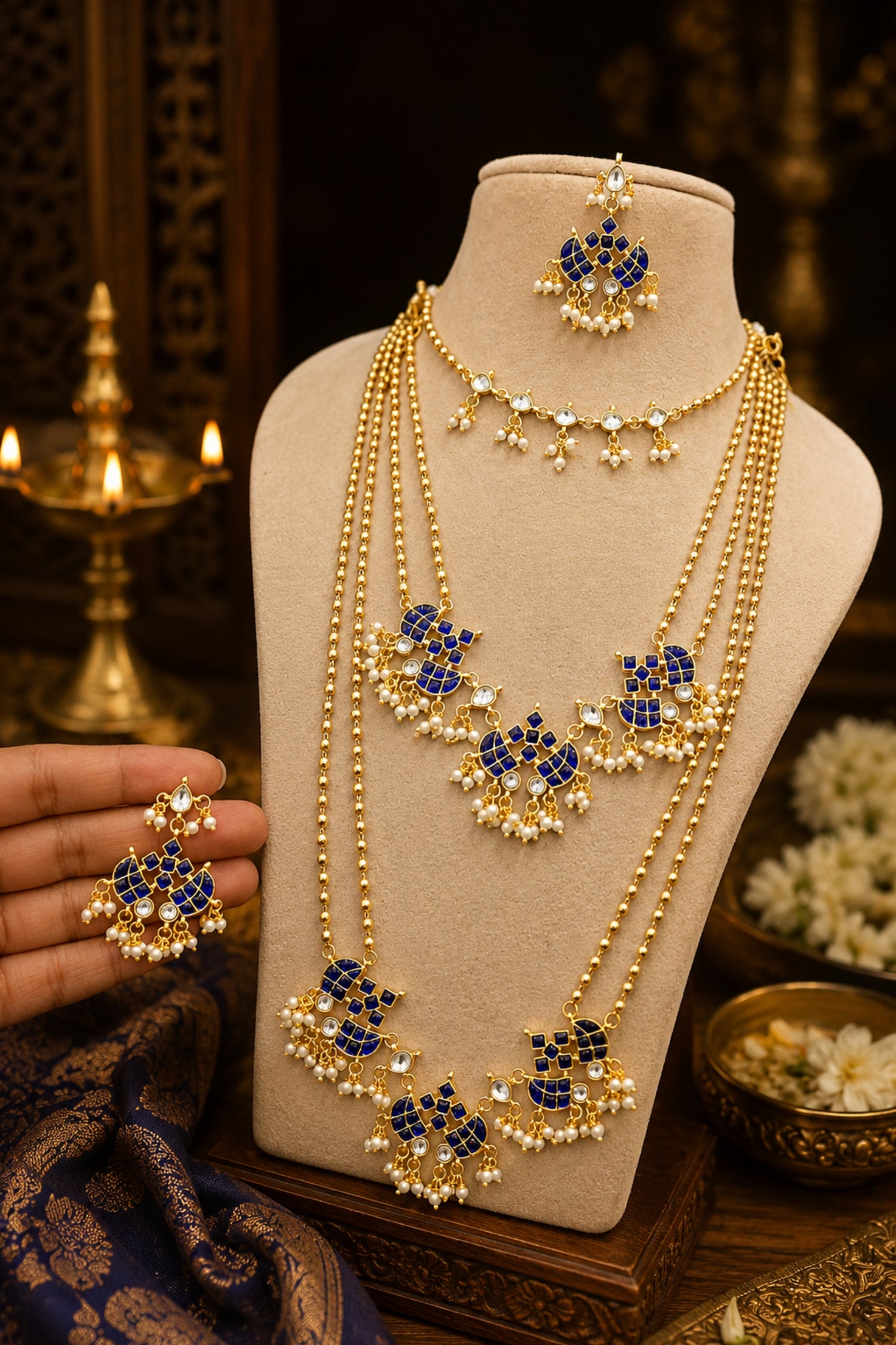 Gold and blue jewelry set on a mannequin bust with a decorative background.