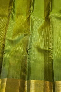 green saree with gold zari border fabric close-up showing the luxurious texture and intricate design.