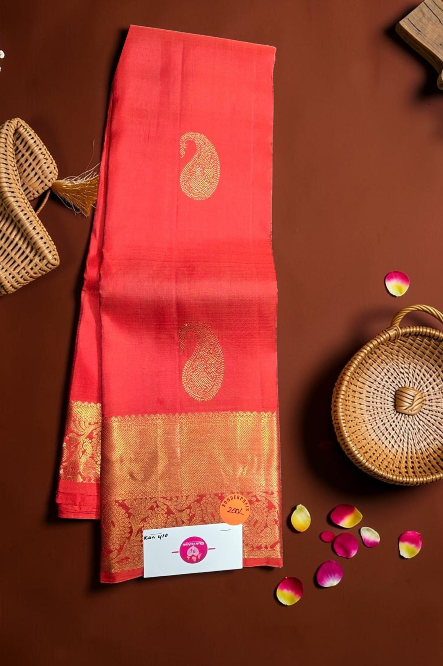 Red saree with gold border on a brown background