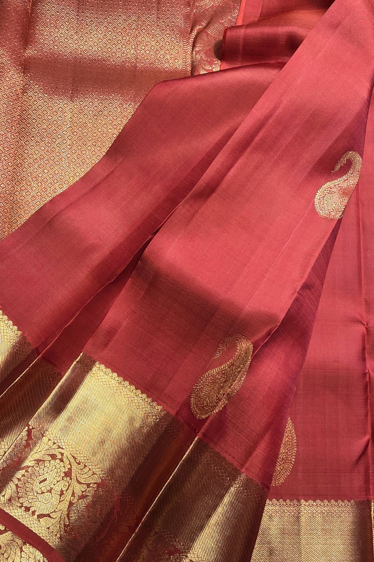 Red saree with gold patterns on a textured background