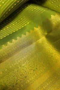 Green saree with gold zari border featuring intricate gold patterns and a luxurious texture.
