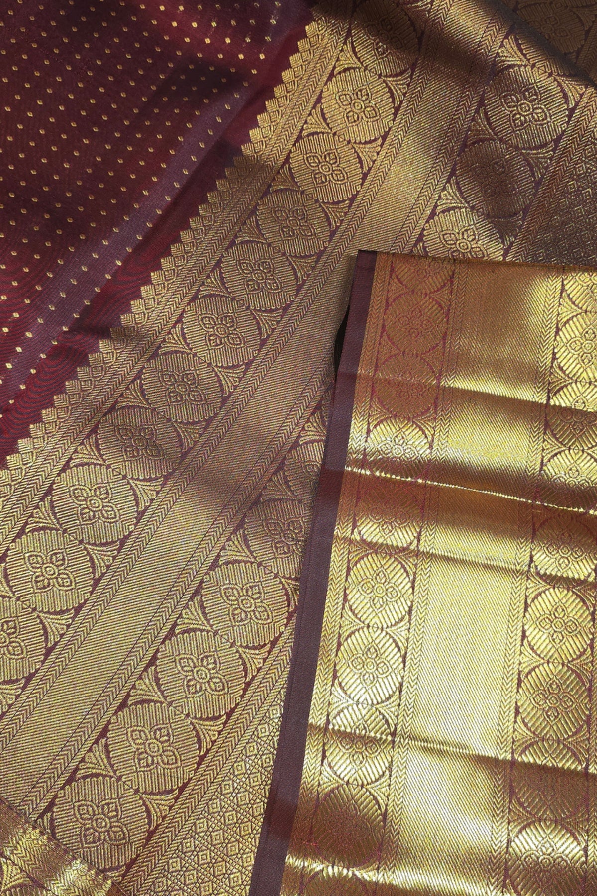 Close-up of a gold and maroon saree with intricate patterns