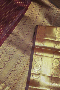 Close-up of a gold and maroon saree with intricate patterns