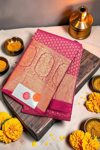 Traditional saree with a brand label on a wooden board surrounded by decorative items.