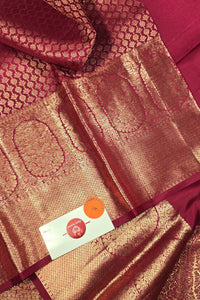 Close-up of a maroon fabric with intricate patterns and a brand label.