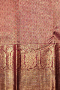Close-up of a pink and gold patterned fabric with intricate designs.