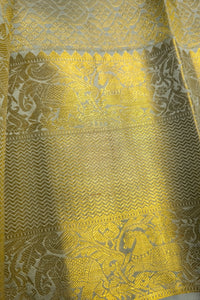 Light sage green silk saree with intricate gold zari border showcasing fine craftsmanship and elegant design.