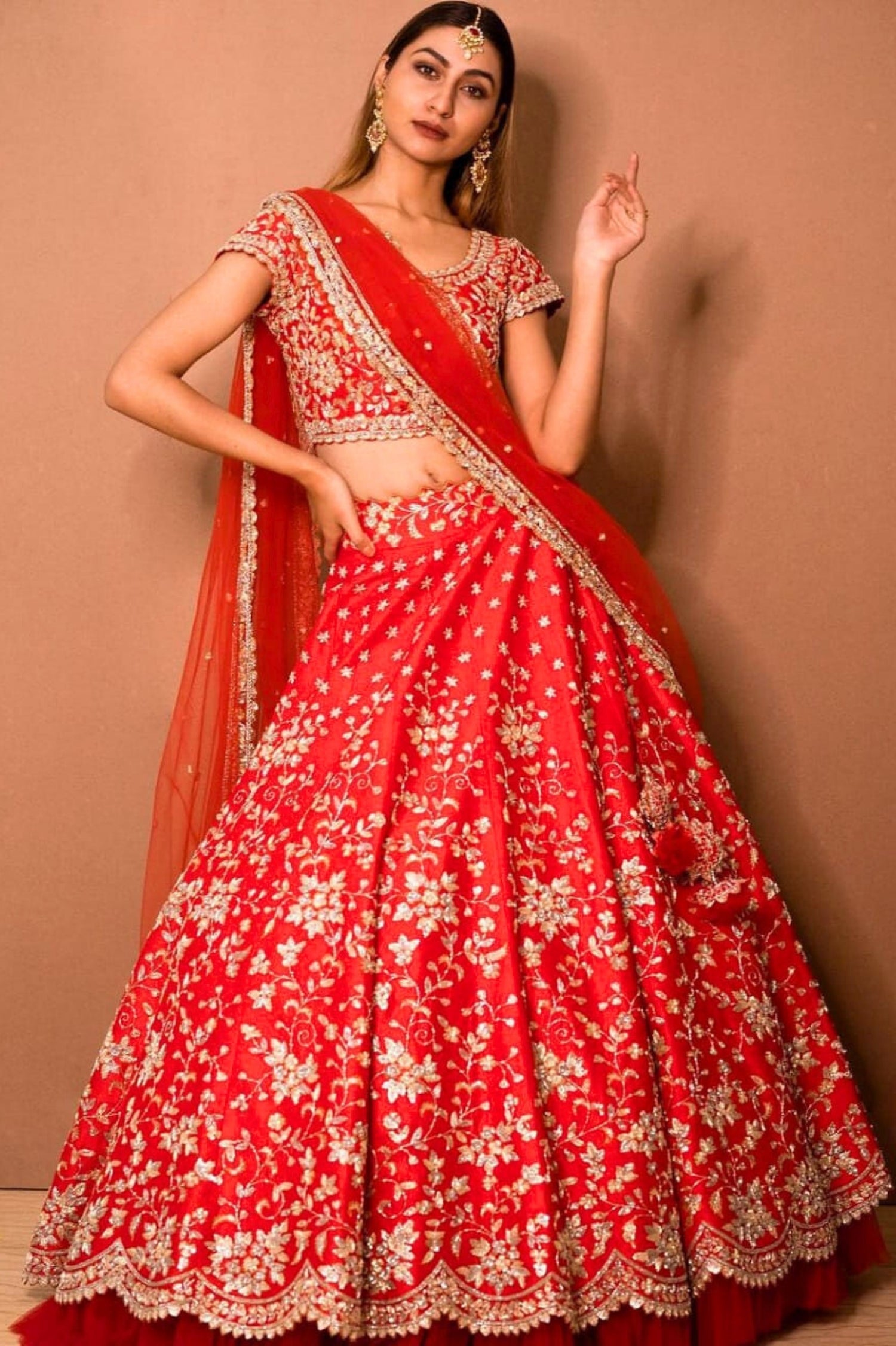 Woman wearing a red and white traditional outfit with a beige background