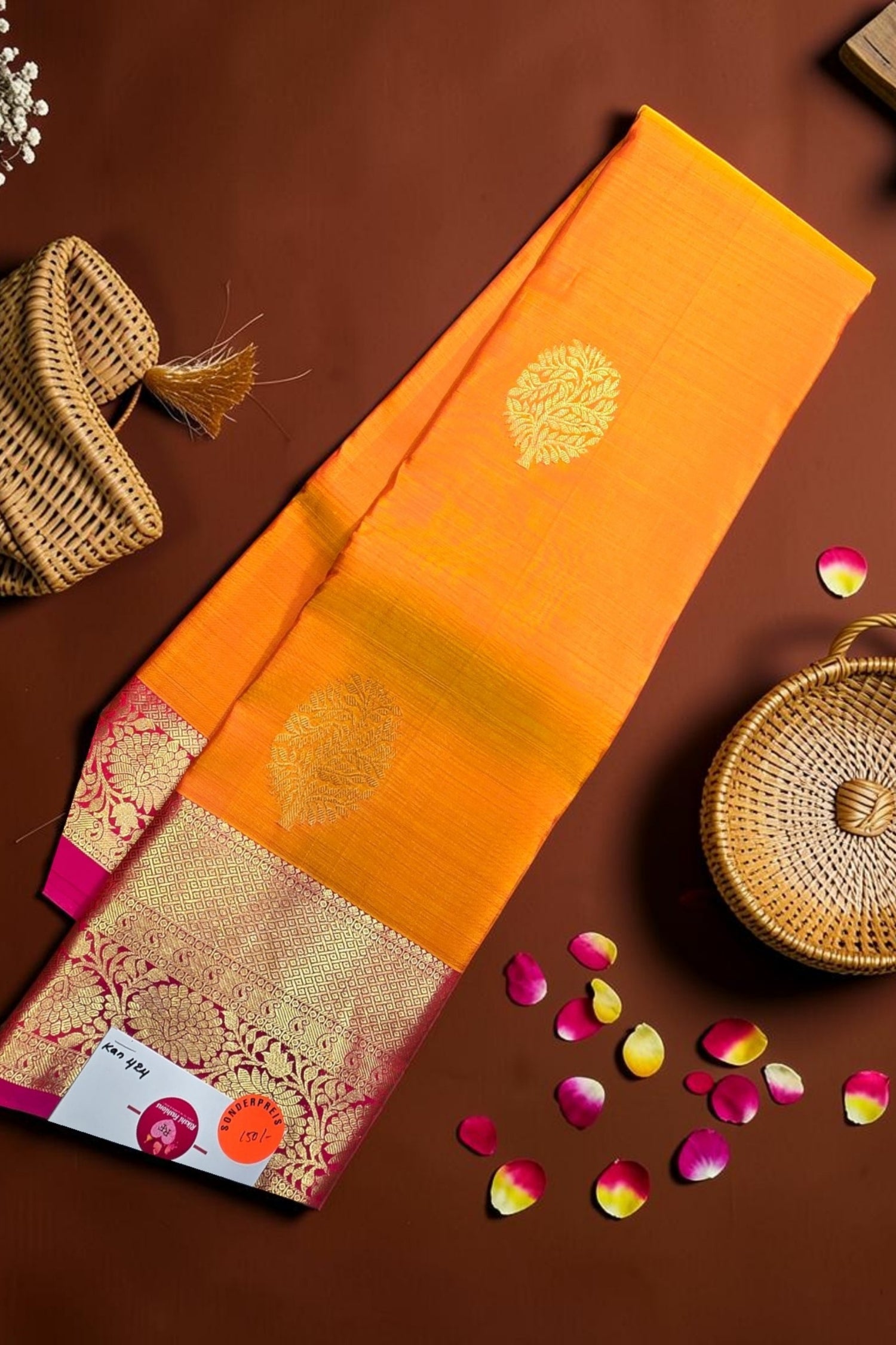Orange saree with gold border on a brown background