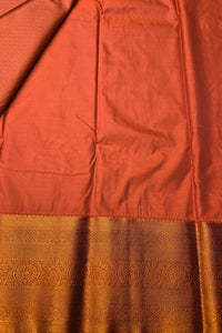 Close-up of a fabric with a rust-colored top and a patterned brown bottom.