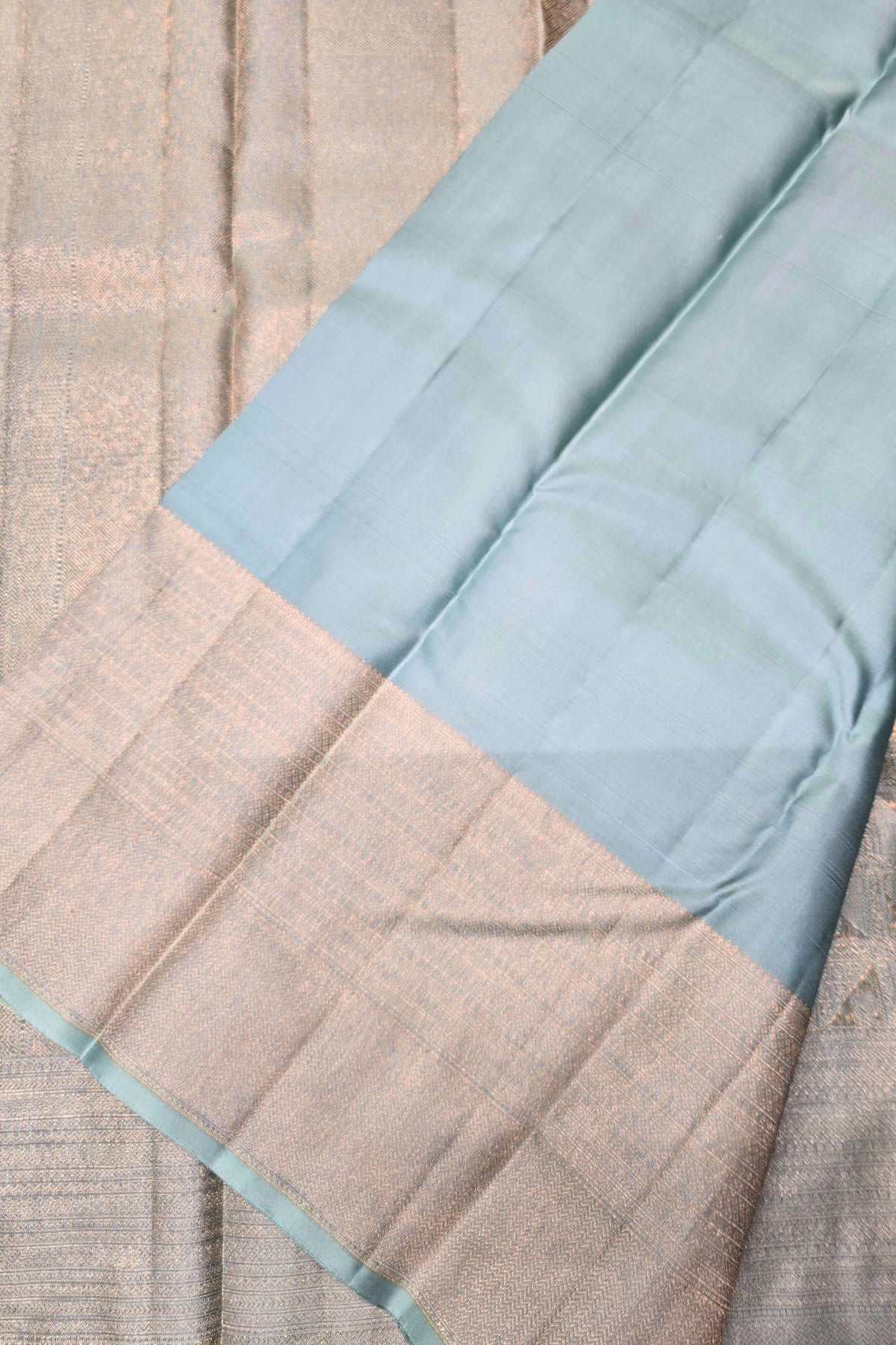 Close-up of a fabric with a light blue border on a textured beige background