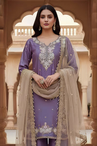 Woman in traditional outfit with intricate embroidery in a decorative setting