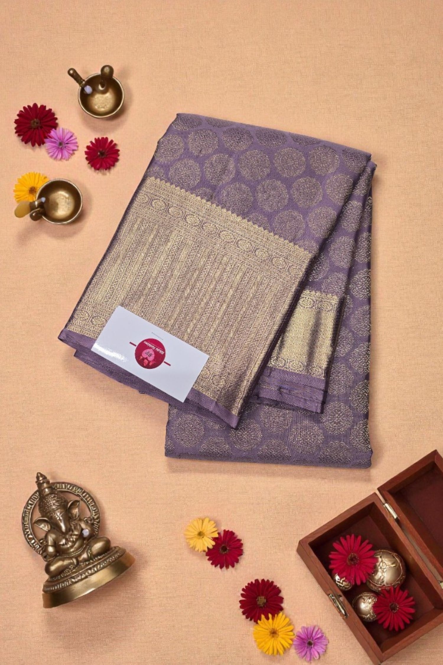 Purple and gold saree with decorative elements on a beige background