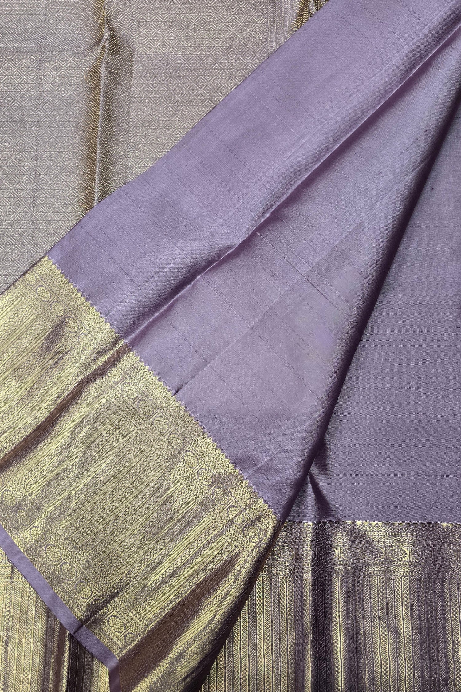 Purple fabric with gold border on a textured surface