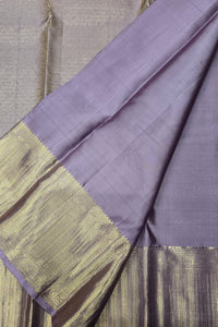 Purple fabric with gold border on a textured surface