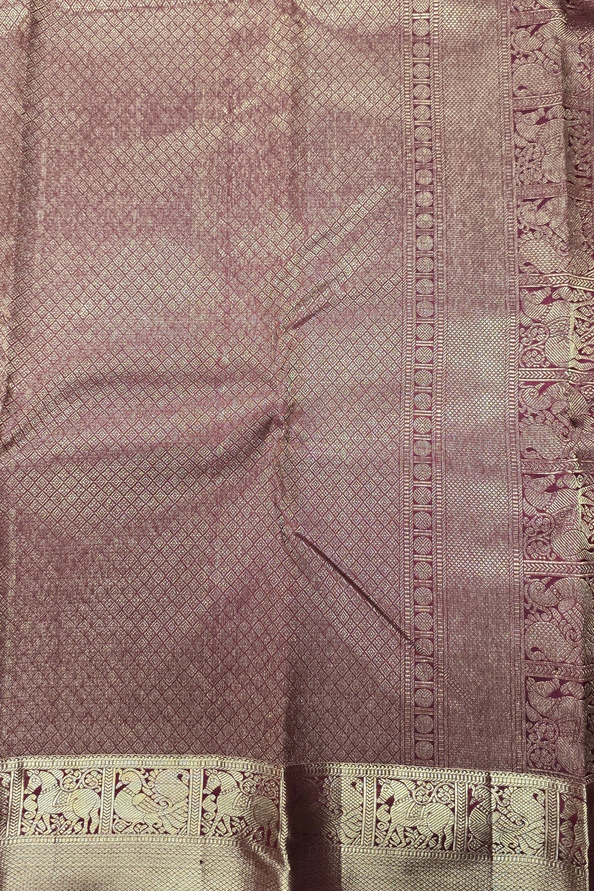 Close-up of a purple fabric with intricate patterns and embroidery.