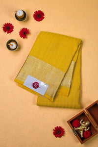 Yellow fabric with a gold border on a beige background with decorative elements.