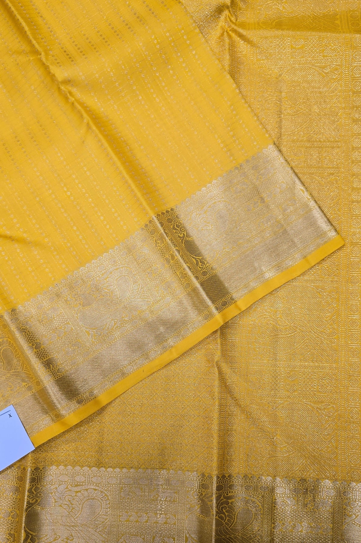 Close-up of a yellow fabric with a gold border