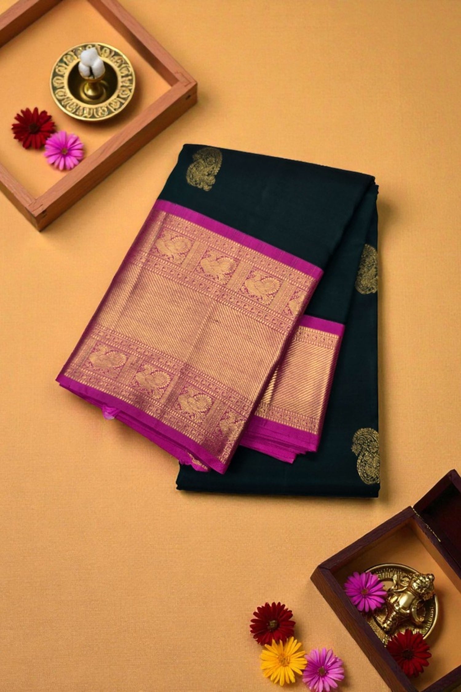 Black saree with pink border on a beige background