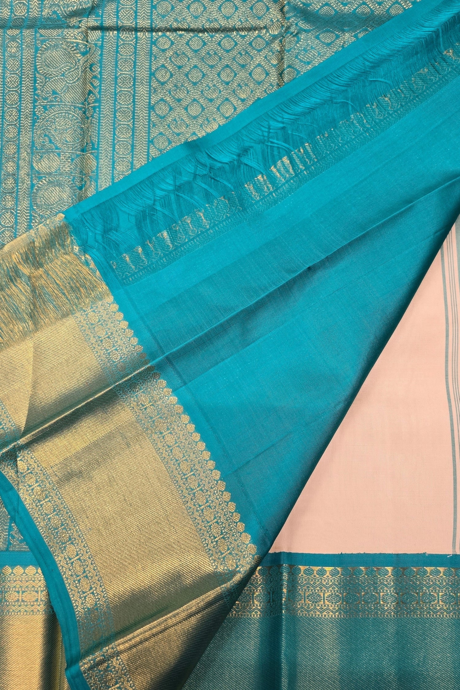 Close-up of a blue and gold saree with a pink fabric underneath