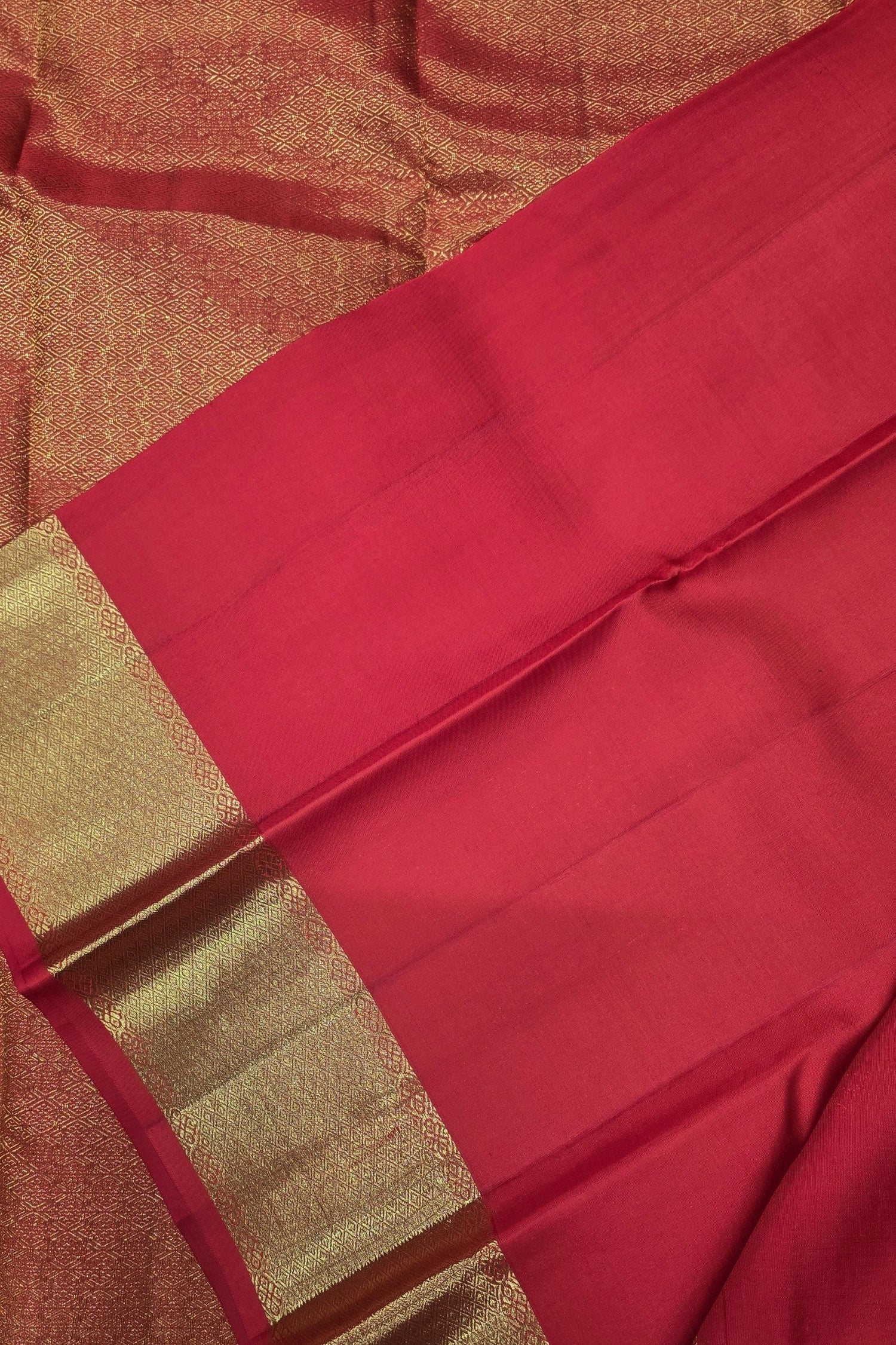 Red fabric with gold border on a textured background
