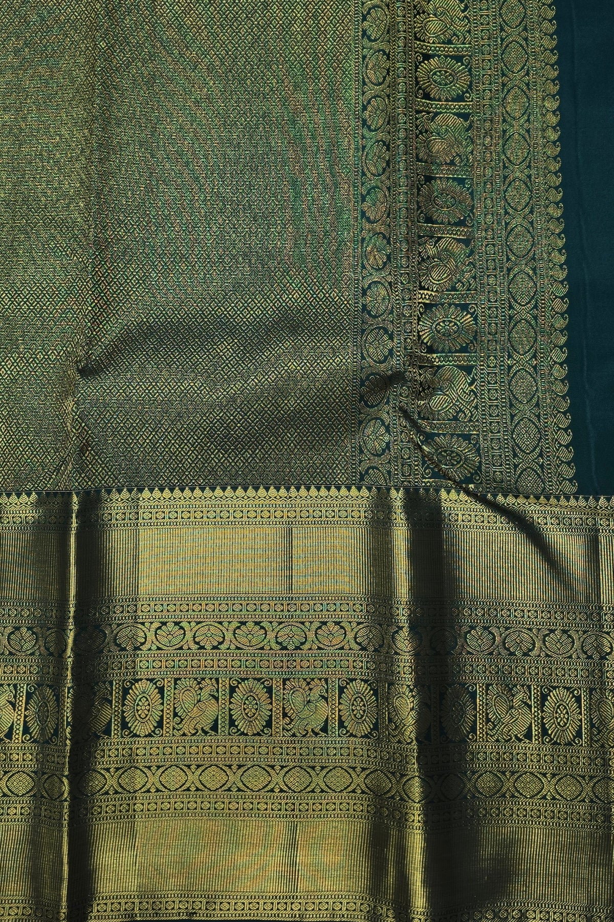Green fabric with intricate gold patterns and embroidery