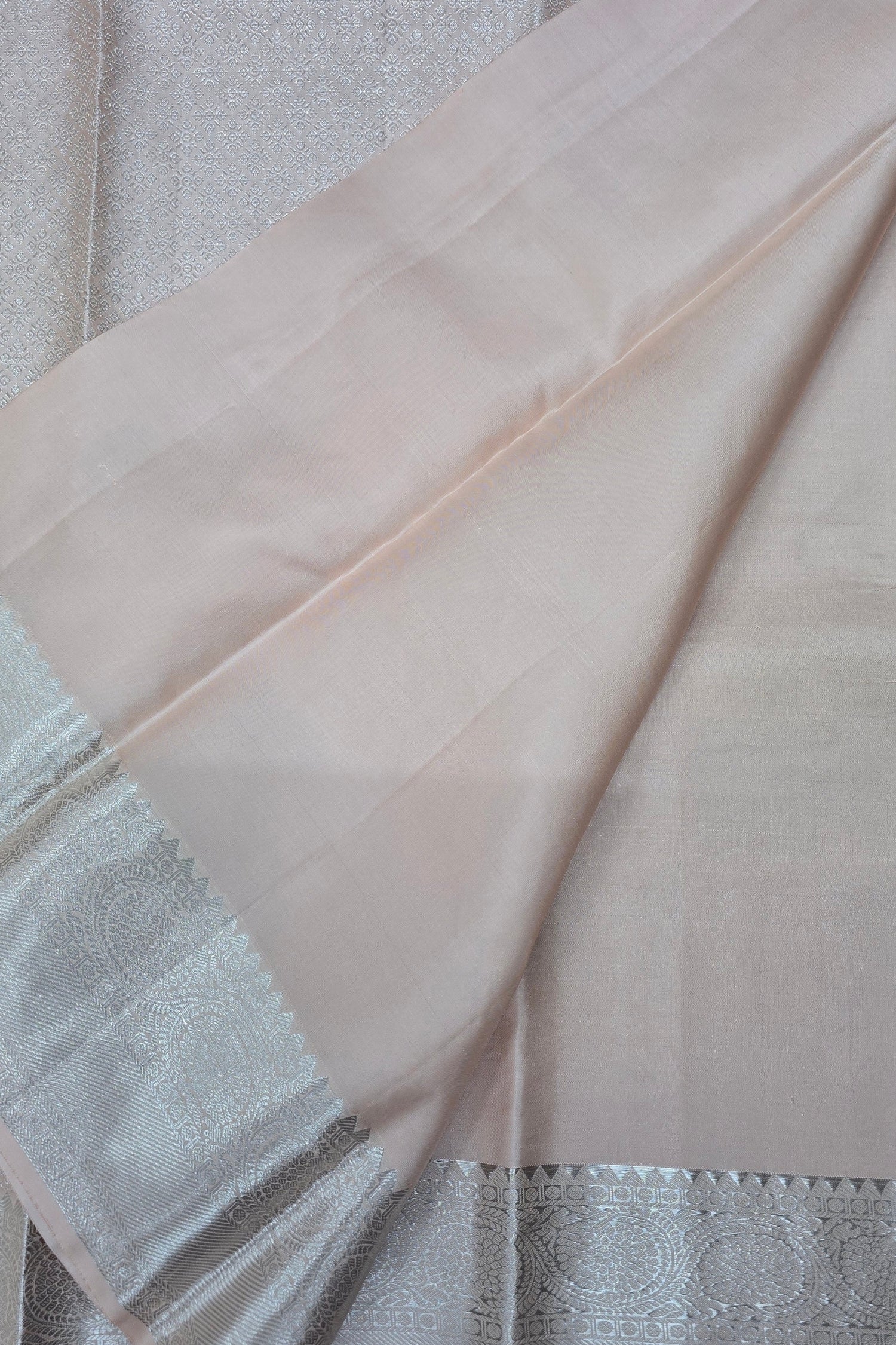 Close-up of a light pink fabric with a textured edge on a neutral background