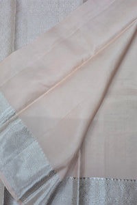 Close-up of a light pink fabric with a textured edge on a neutral background