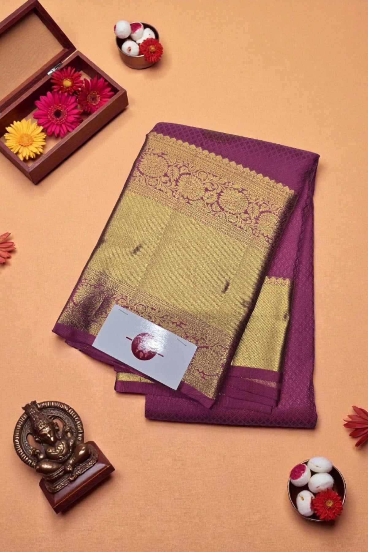 Purple and gold saree with decorative elements on a beige background