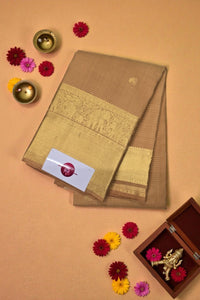 Brown saree with gold border on a beige background with decorative elements