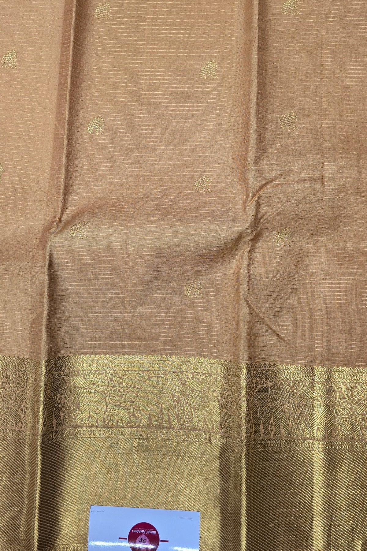 Brown fabric with a decorative border featuring elephants, on a plain background.