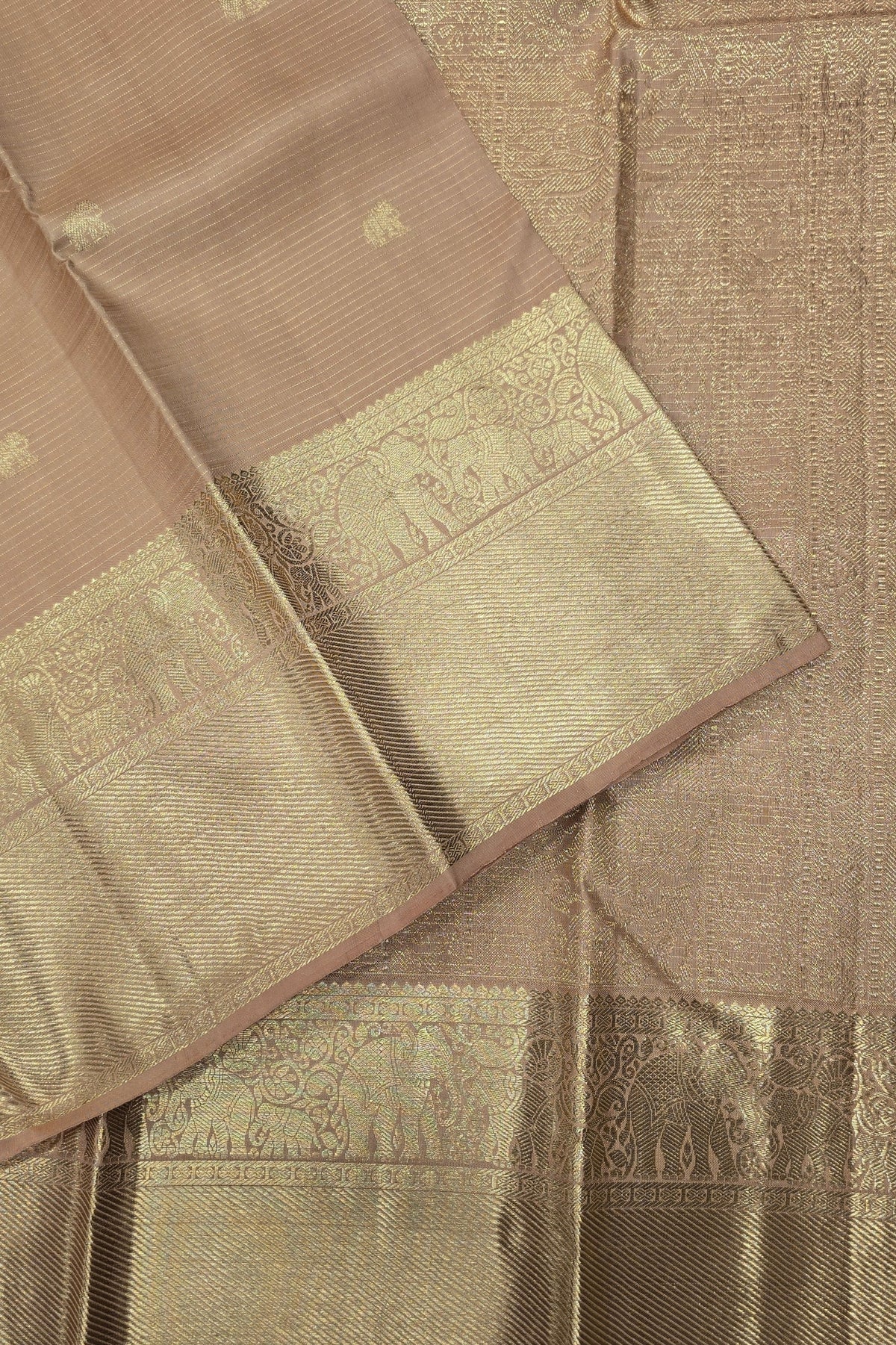 Close-up of a brown saree with gold border and patterns