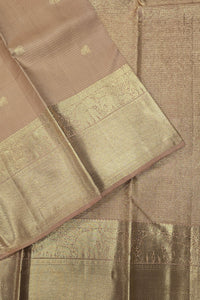 Close-up of a brown saree with gold border and patterns