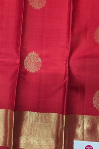 Red fabric with gold patterns and a visible brand label.