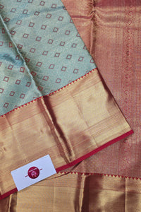 Close-up of a traditional saree with intricate patterns and a brand label.