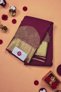 Maroon and gold saree with a card on an orange background