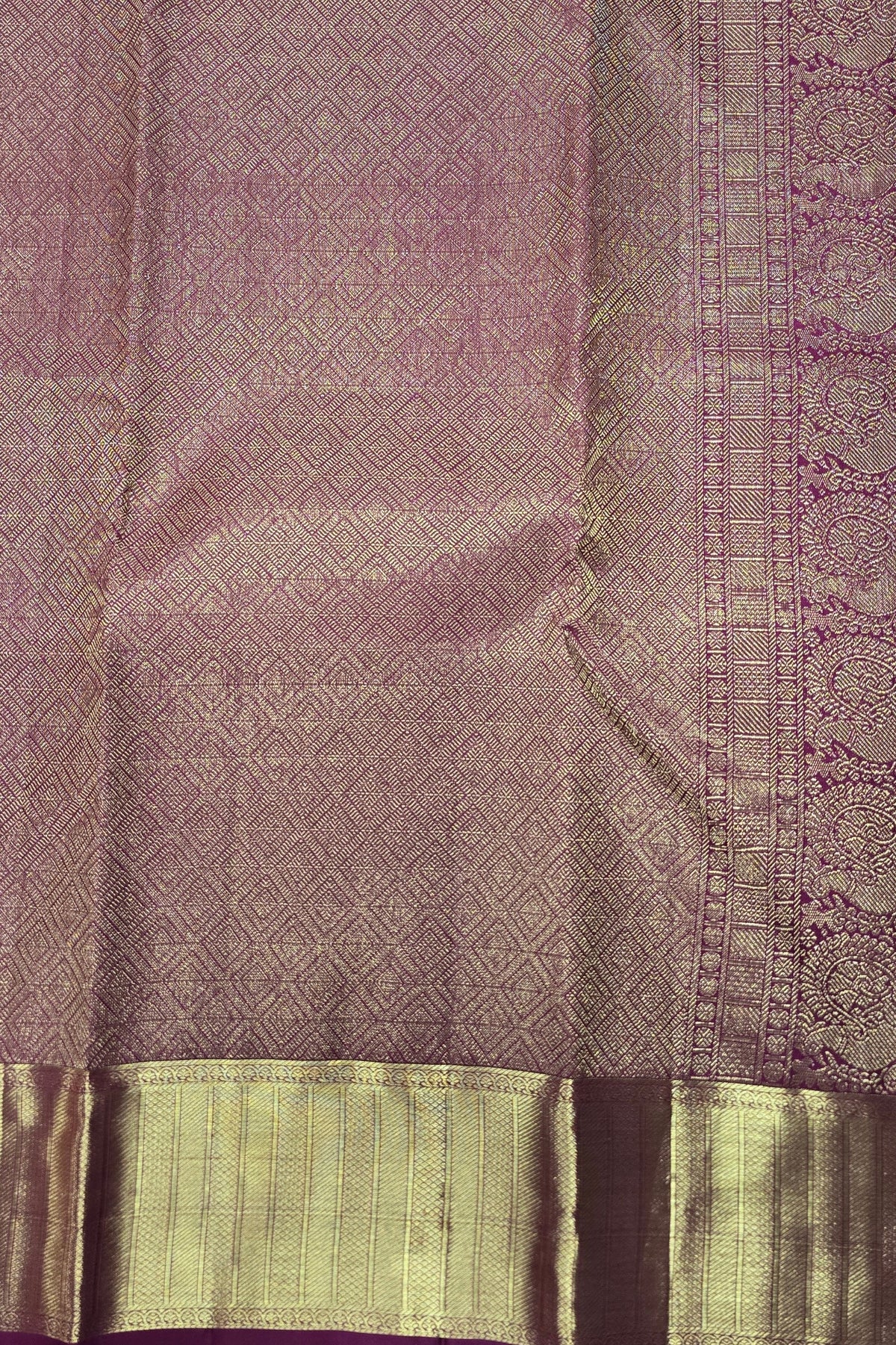 Purple fabric with intricate patterns and a green border