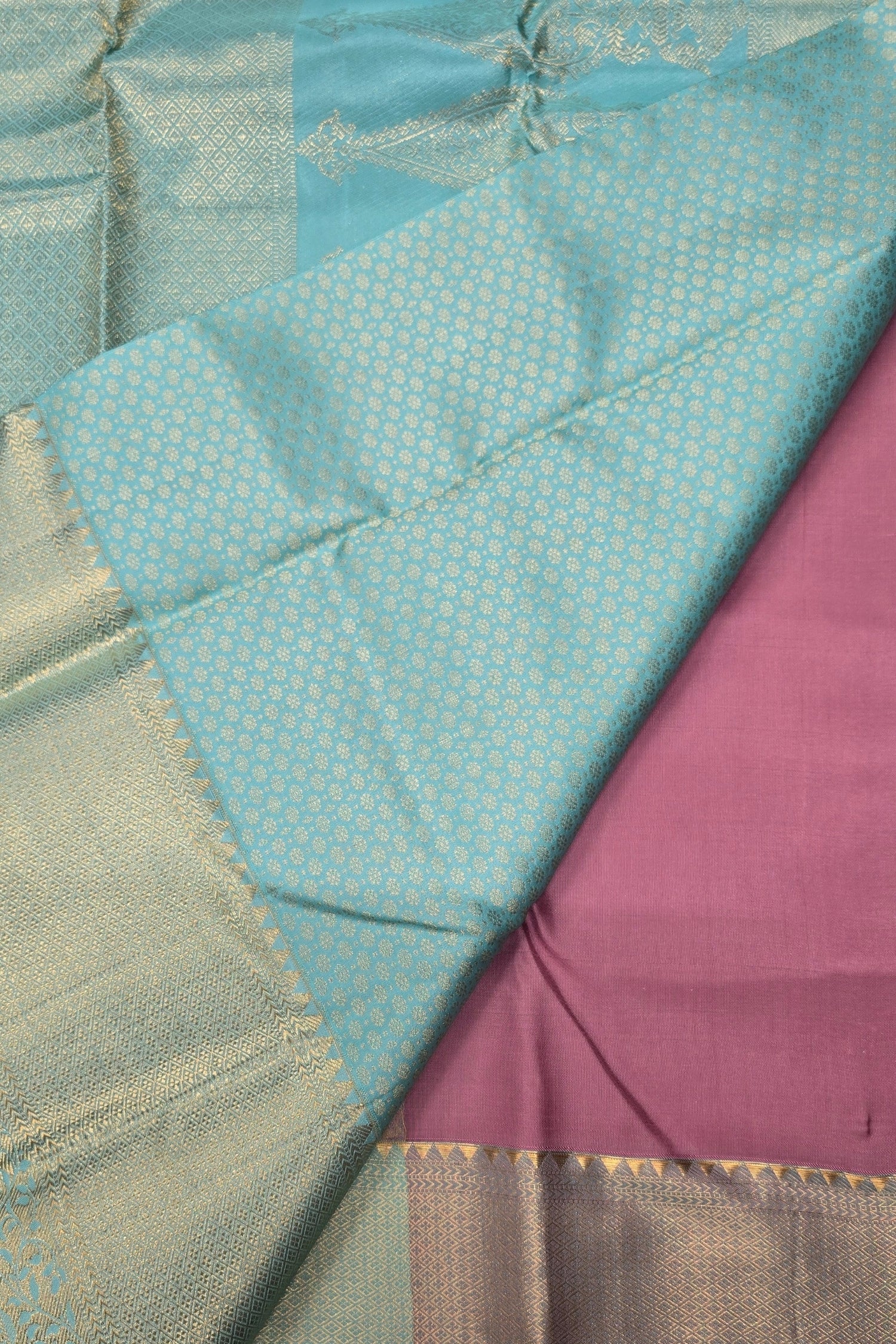 Close-up of a fabric with teal, purple, and gold patterns