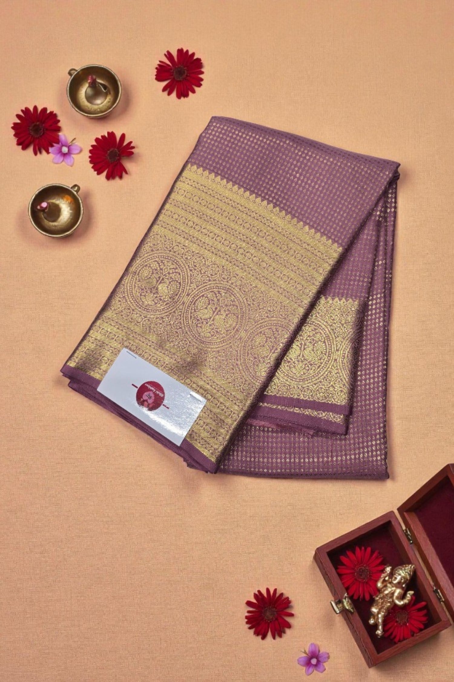 Purple and gold saree with decorative elements on a beige background