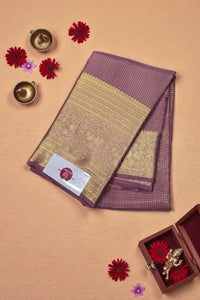 Purple and gold saree with decorative elements on a beige background