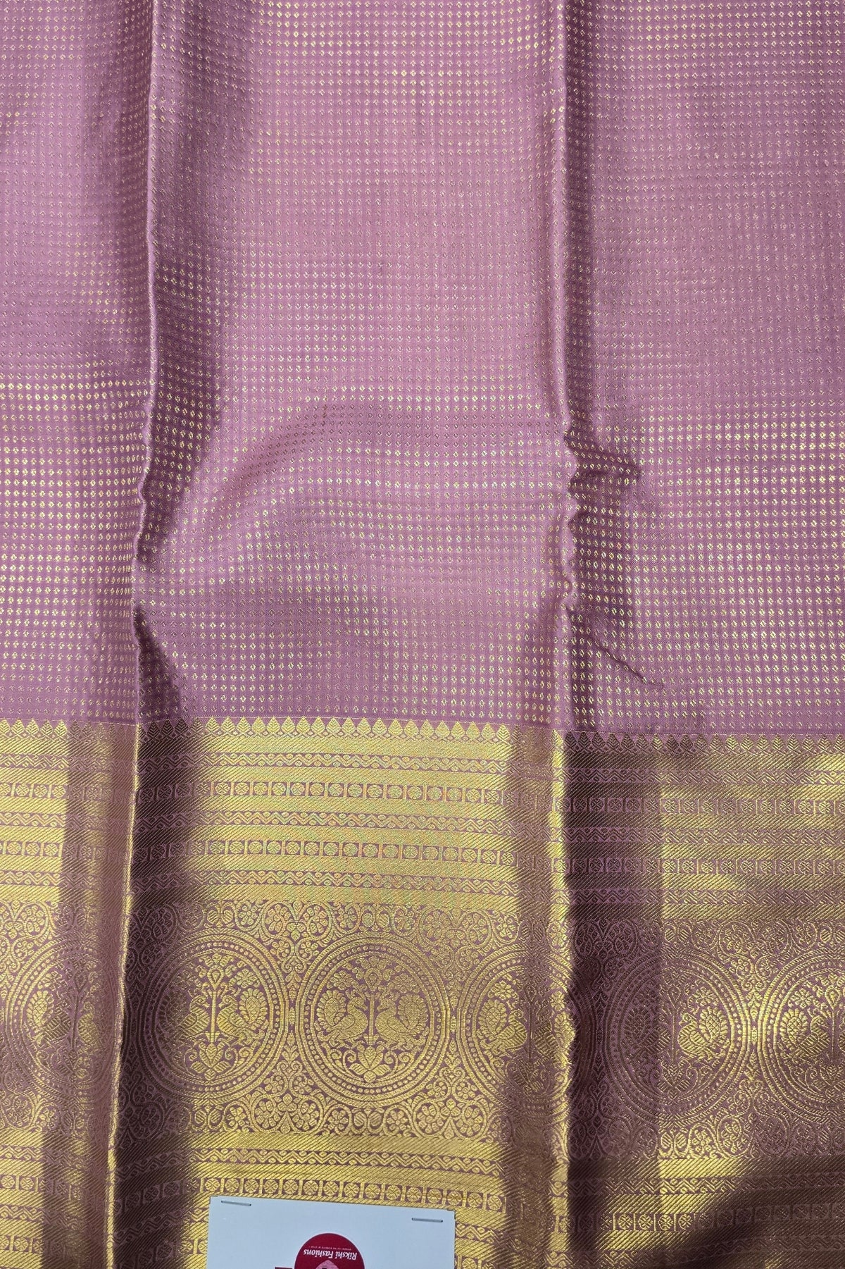 Purple fabric with gold patterns and a visible brand label.