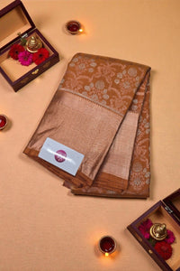 Brown saree with floral patterns on a beige background