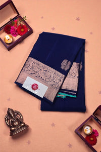 Navy blue saree with intricate patterns on a peach background