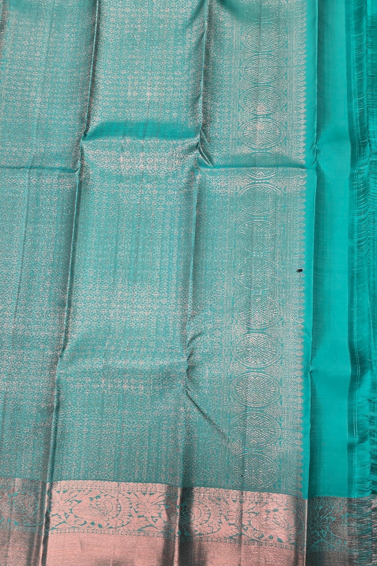 Close-up of a teal fabric with a subtle pattern