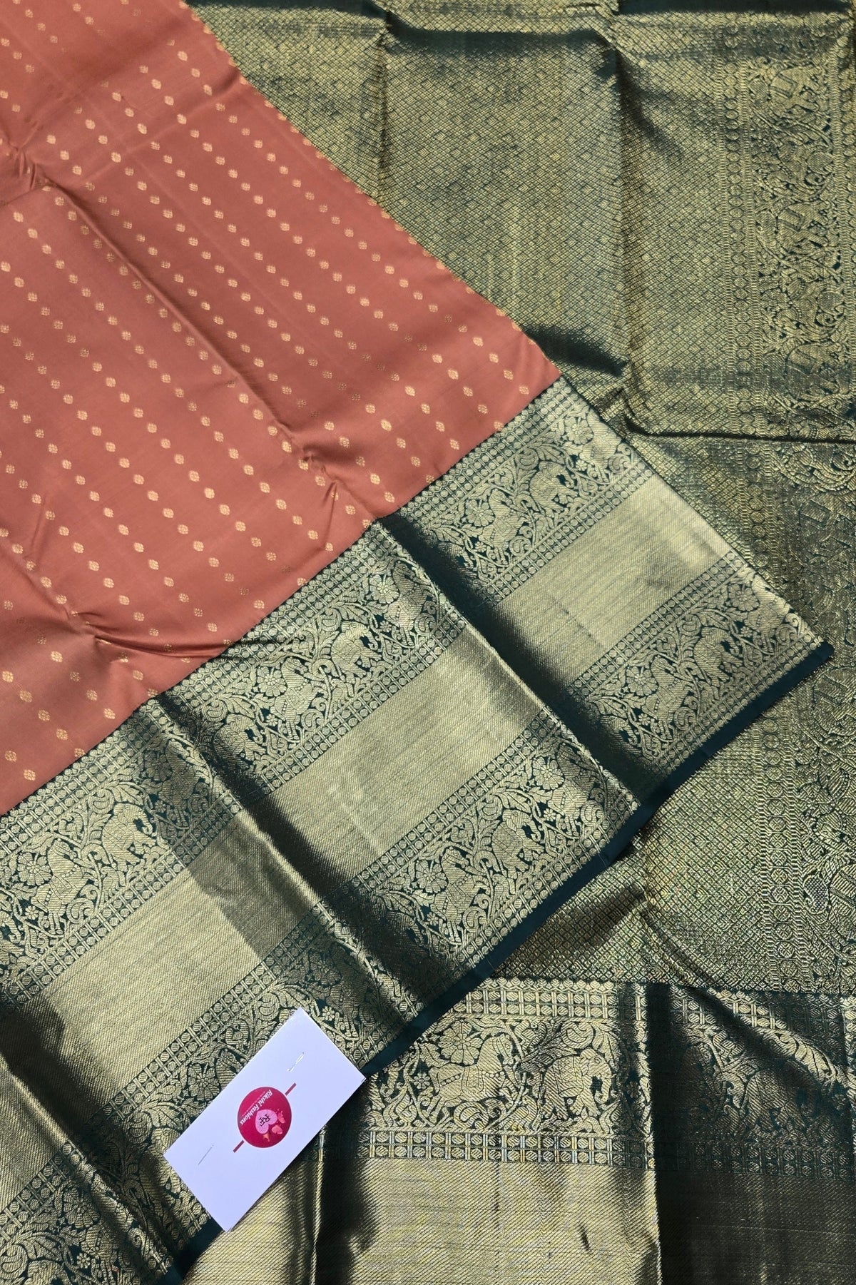 Green and brown fabric with intricate patterns and a visible brand label.