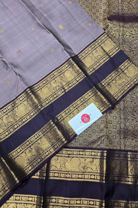 Gray saree with gold and black border and a visible brand label.
