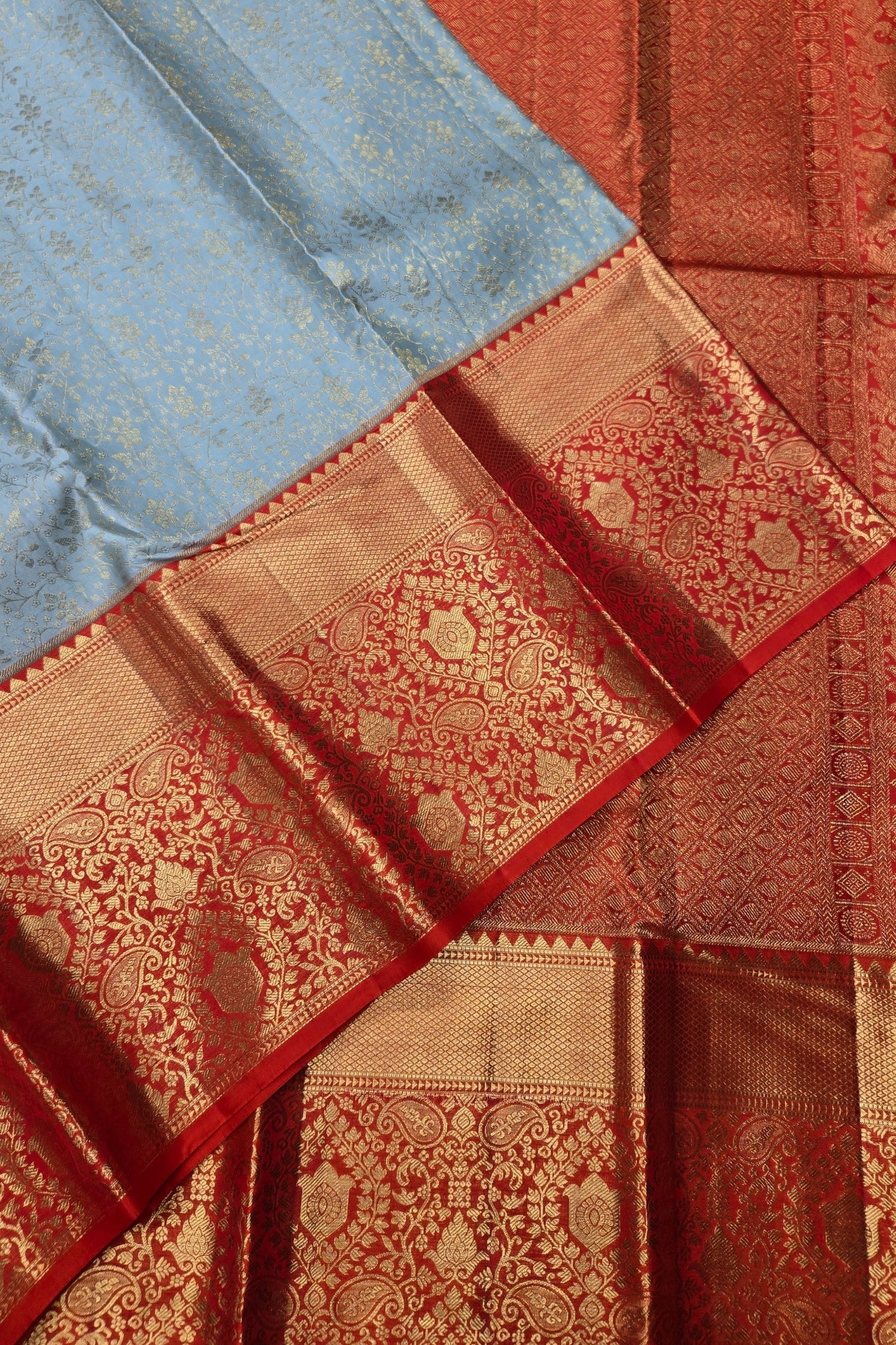 Close-up of a traditional saree with intricate patterns in red and blue.